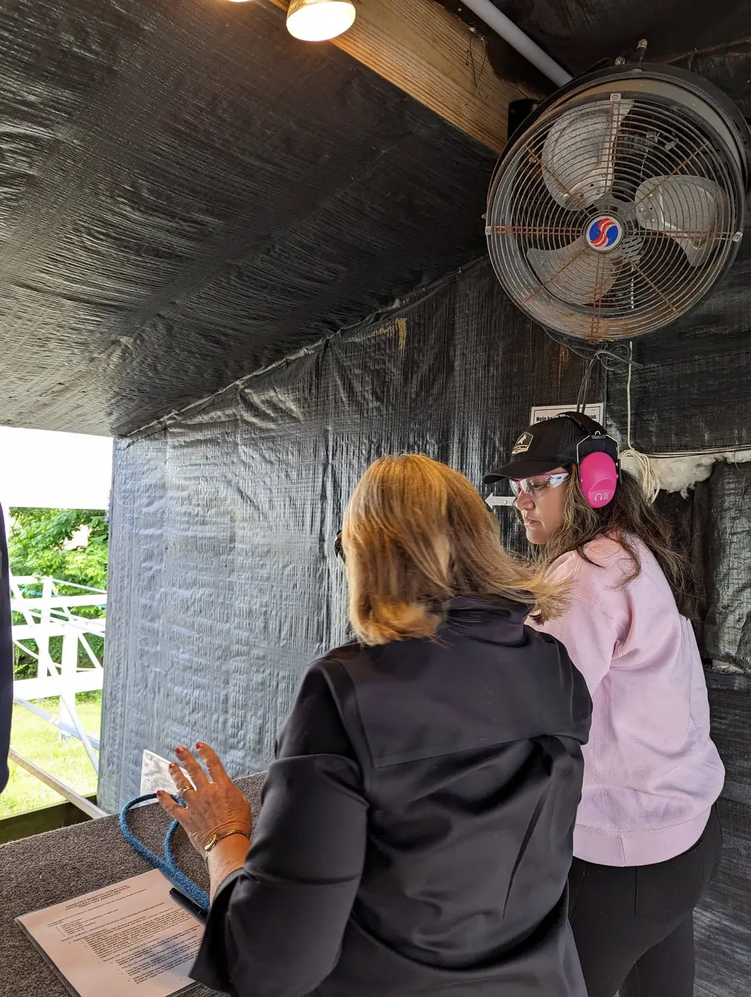 Instructor coaching a new shooter wearing hearing protection